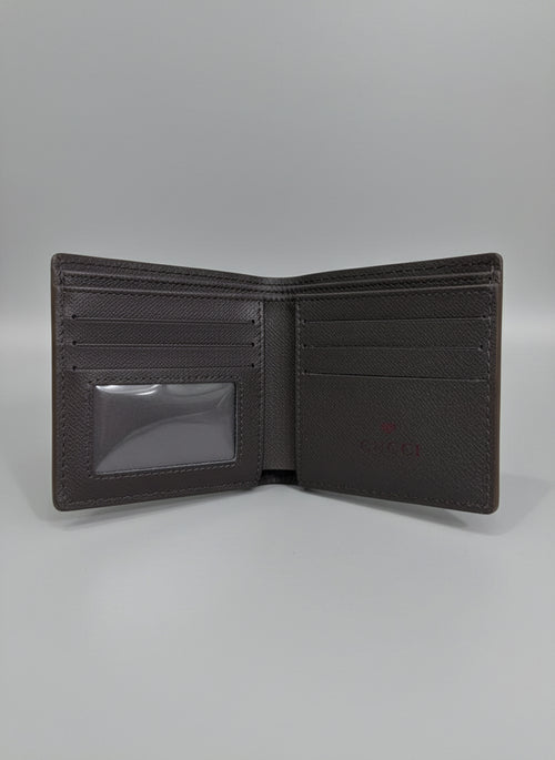 Brown leather wallet with Gucci logo on a clear plastic sheet