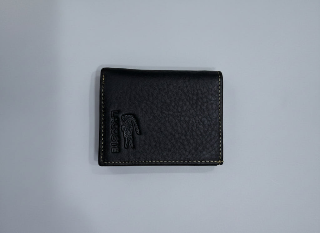 Black leather wallet with brand logo on a textured gray surface