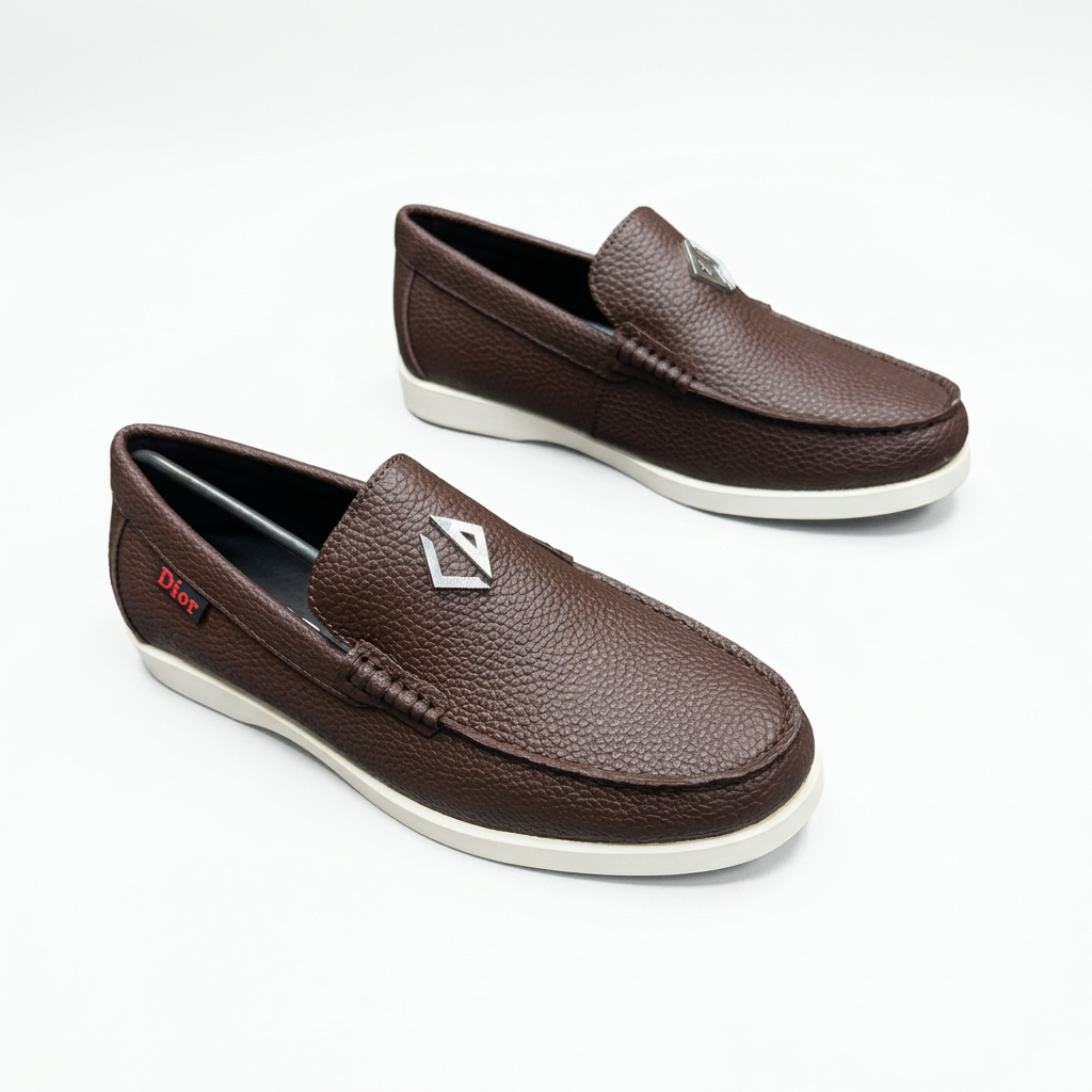 Dark brown textured slip-on loafers with stitched toes and white soles on white