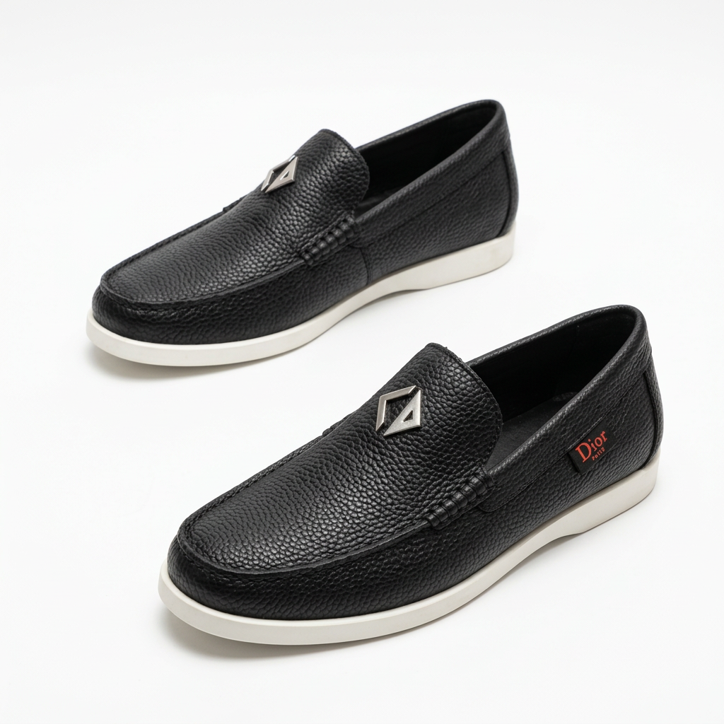 Black textured slip-on loafers with stitched toes and white soles on white