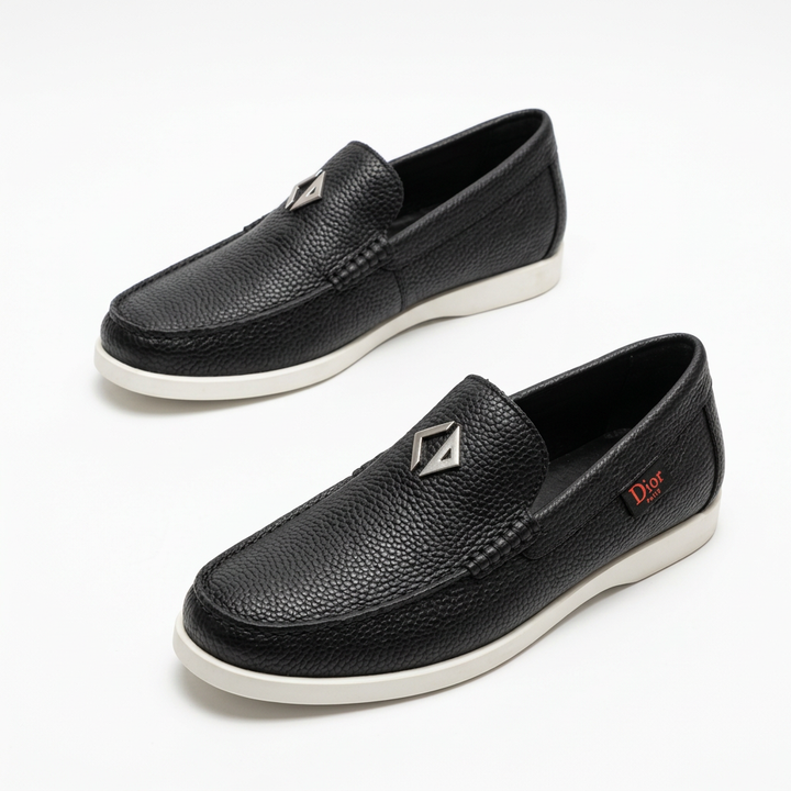 Black textured slip-on loafers with stitched toes and white soles on white