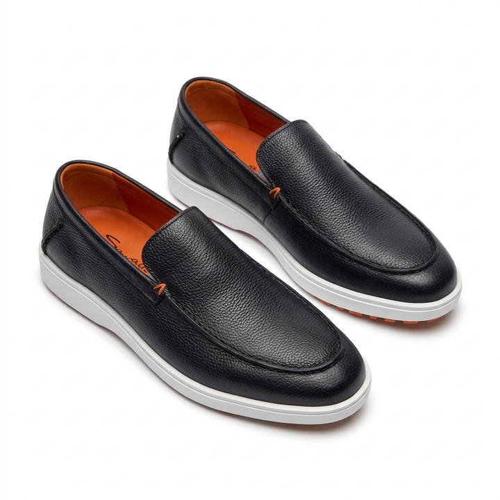 Black textured slip-on loafers with white sole edges and orange lining on white