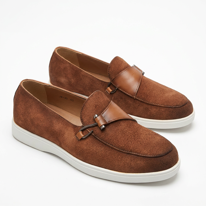 Tan slip-on loafers with metal-loop detail and white soles on white